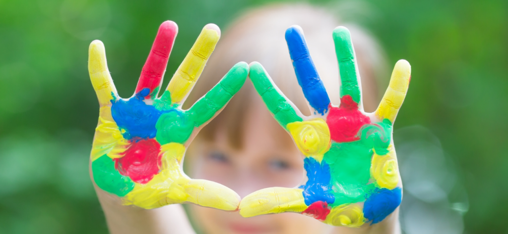 a child's hands painted with yellow, blue, red and green paint